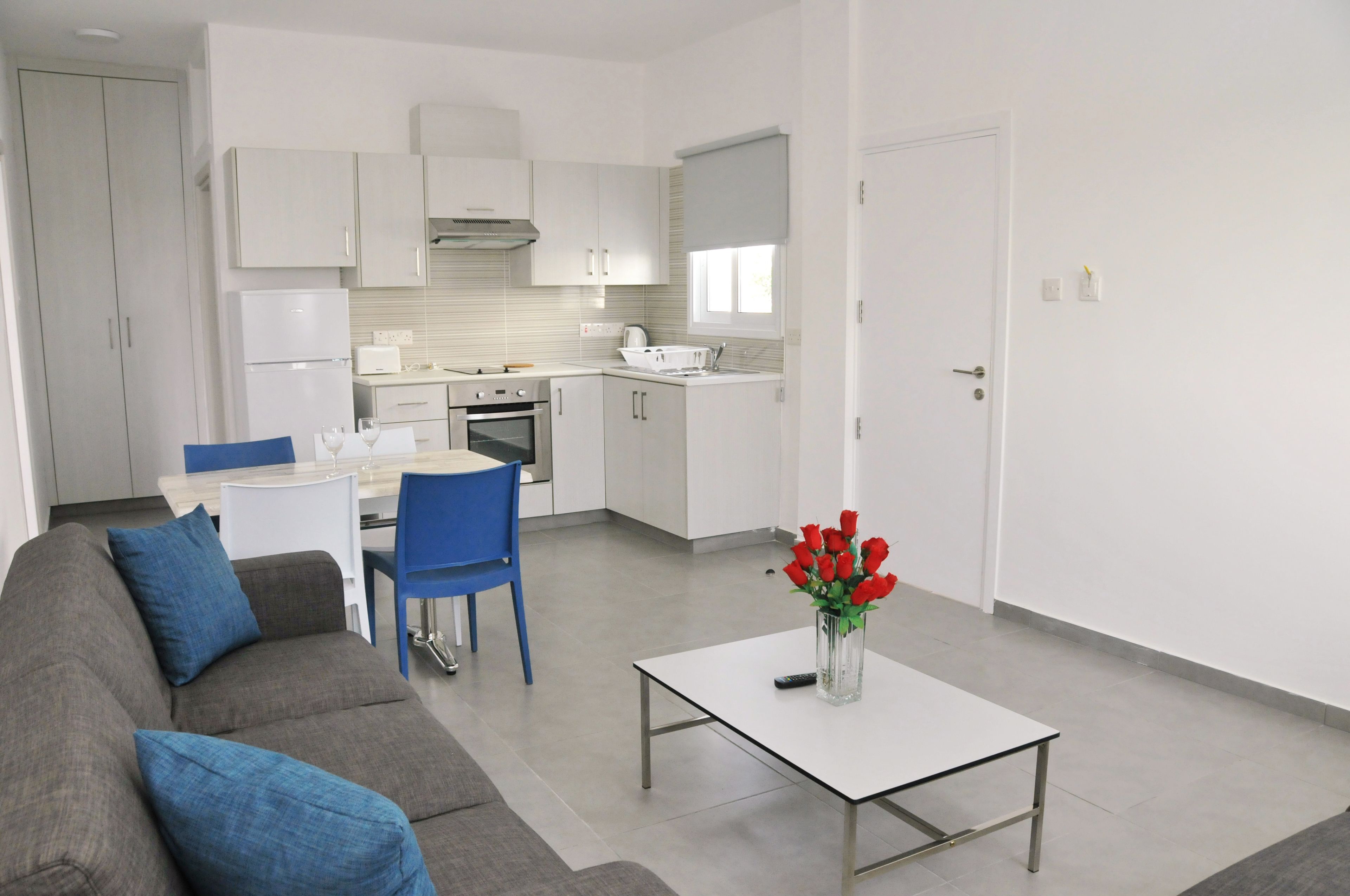 A modern apartment with a kitchen, dining area, and living room.