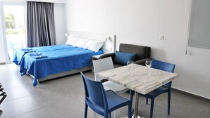 Une chambre d’hôtel avec un lit, une table à manger avec des chaises et une vue sur l’extérieur.