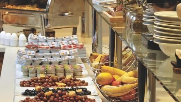 A buffet with various food items and a chef in the background. - Susuzlu Hotel (Izmir)