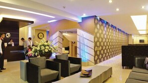 A hotel lobby with a reception desk, seating area, and a staircase. - Susuzlu Hotel (Izmir)