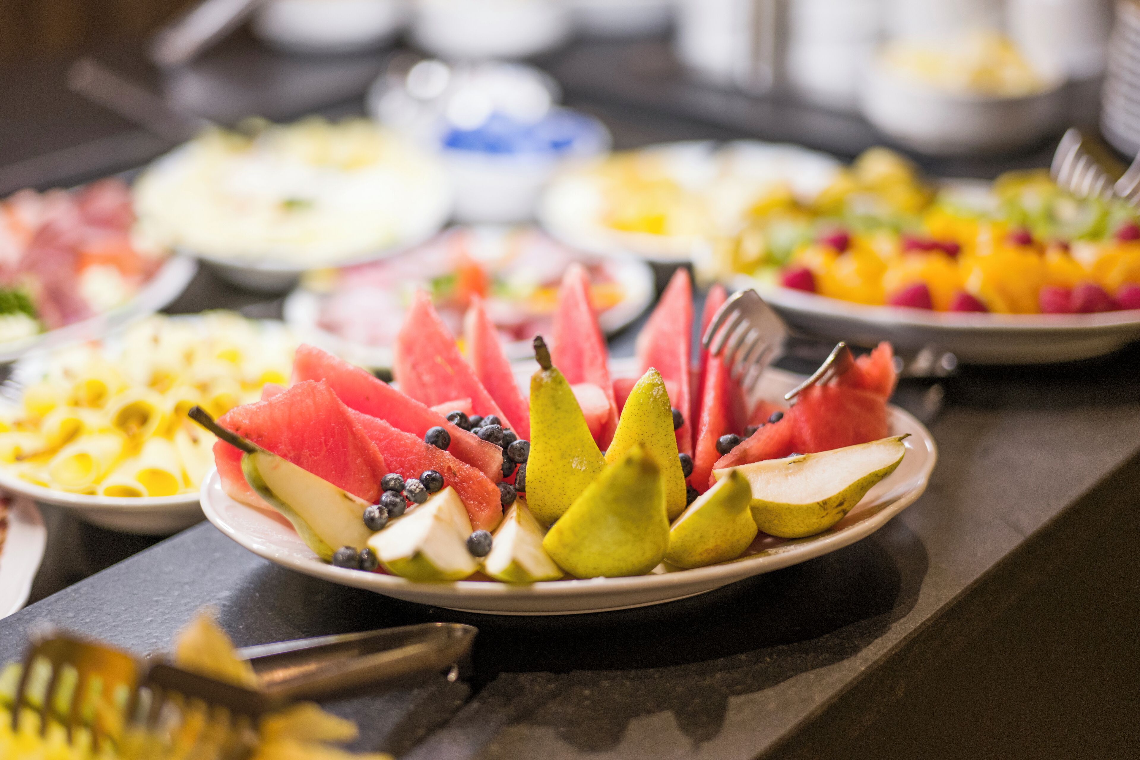 Une table de buffet proposant divers plats à base de fruits et de légumes.