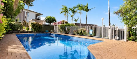 Una piscina al aire libre, tumbonas