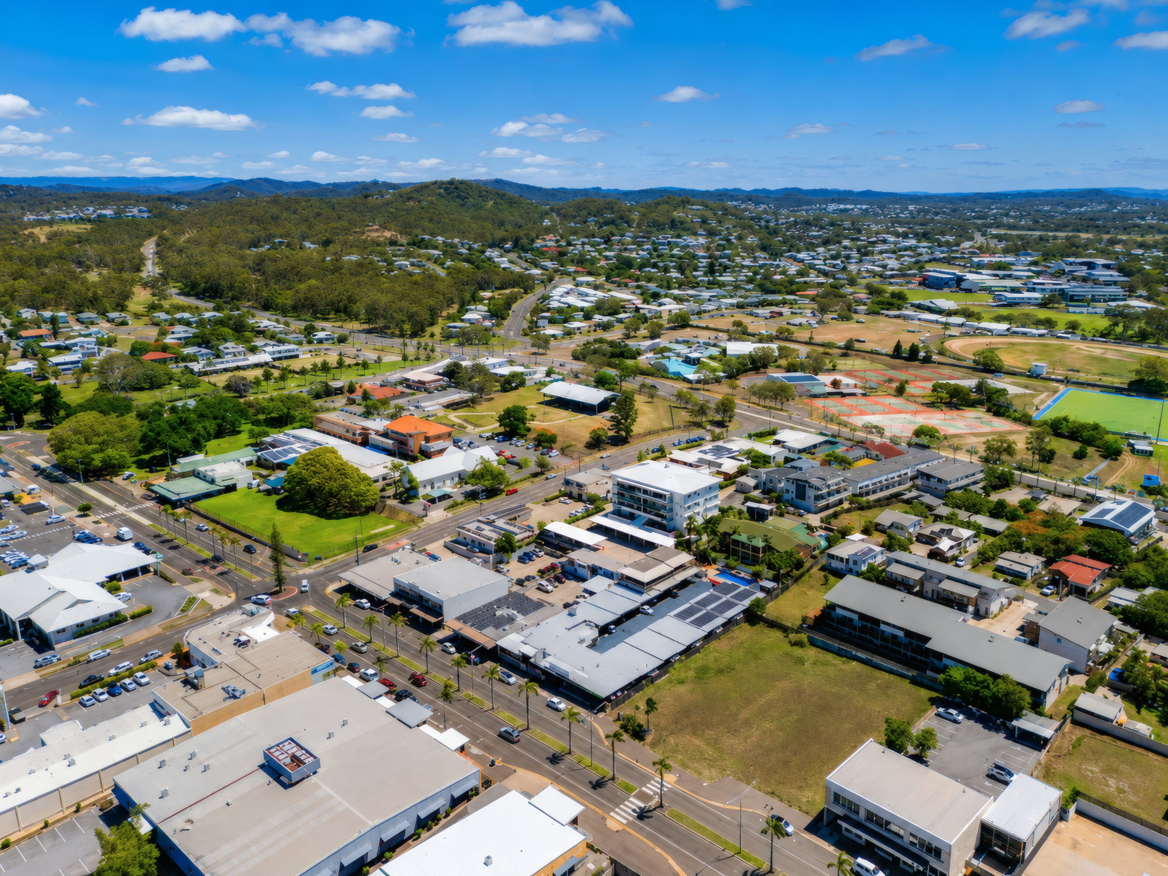 An aerial view of a residential area with houses, roads, and green spaces.