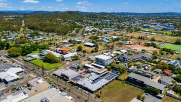 An aerial view of a residential area with houses, roads, and green spaces.