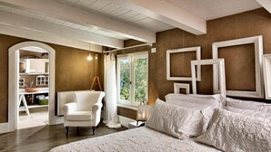 A bedroom with a large bed, a chair, a window, and a view of the outdoors. - La Pampa Relais (Melizzano)