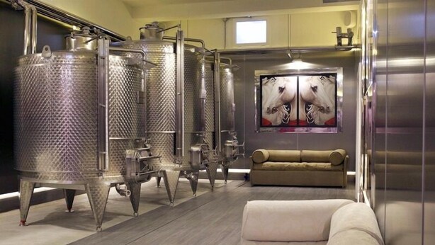 A modern hotel room with a large bed, a sofa, and a painting of horses on the wall. - La Pampa Relais (Melizzano)