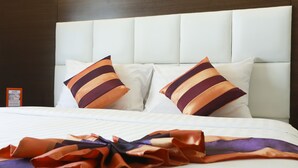 A neatly made bed with two pillows and a decorative blanket. - Studio Nana (Bangkok)