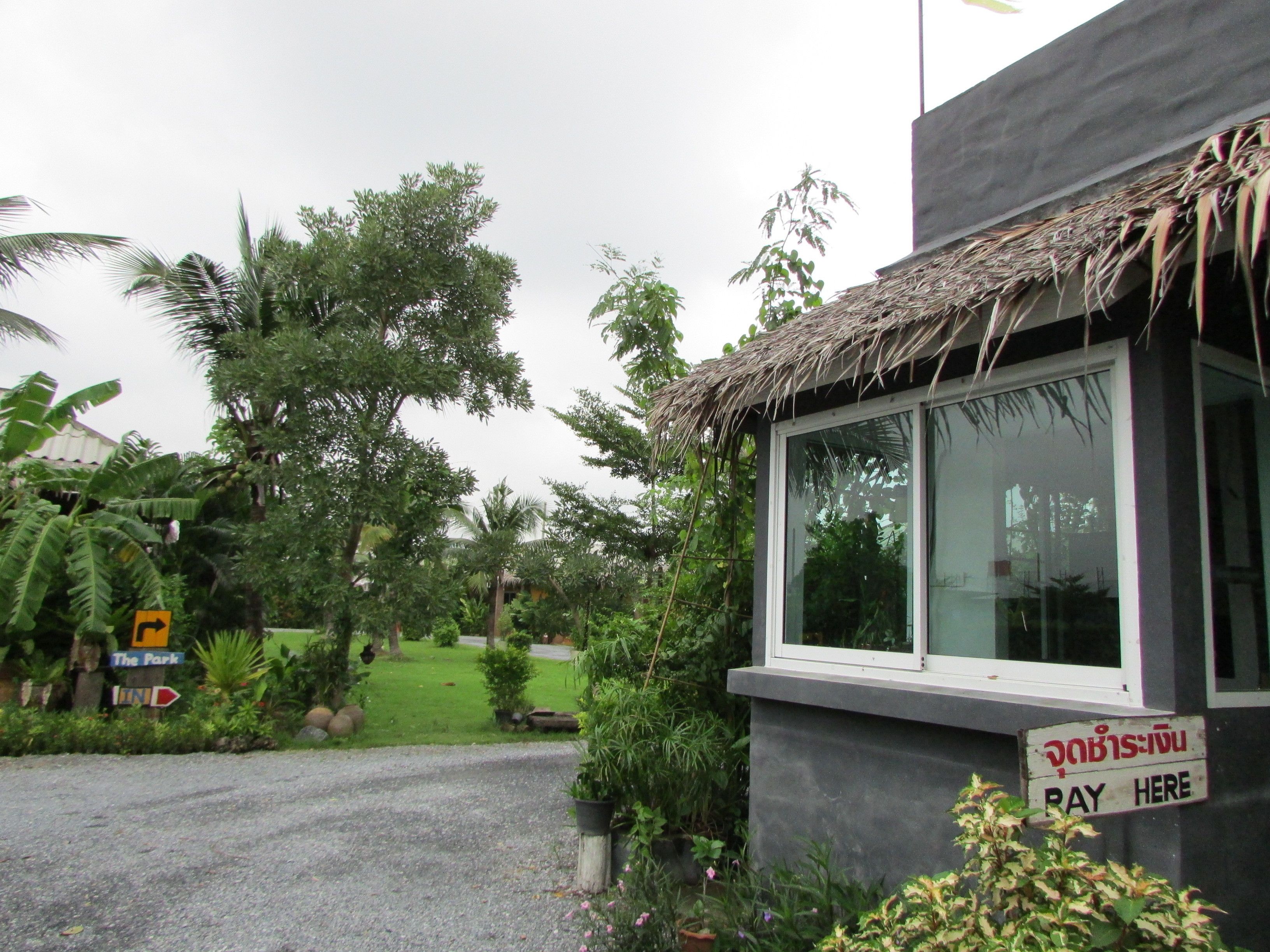 A building with a thatched roof, a window, and a 'PAY HERE' sign.