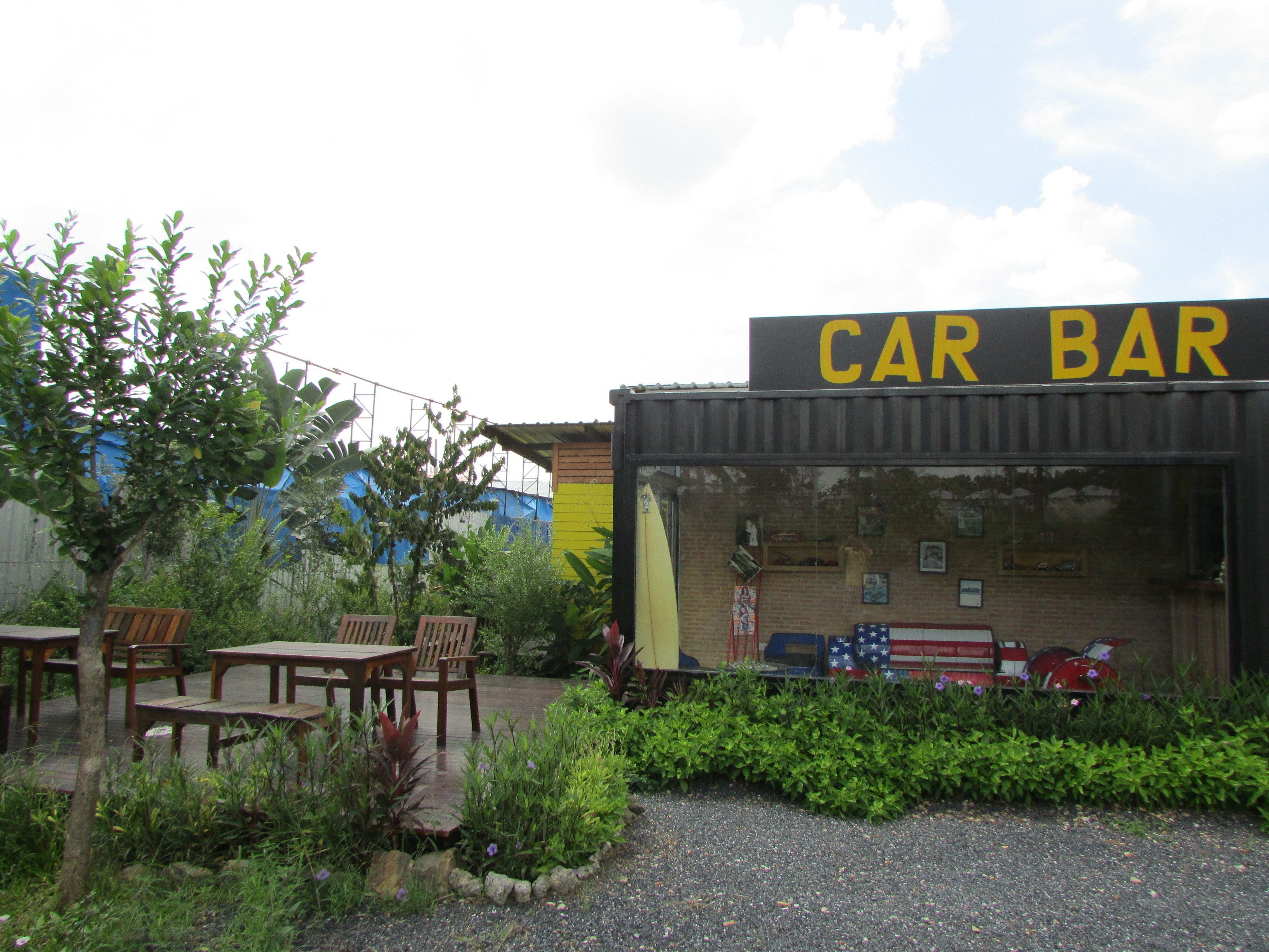 Un bar con temática de autos, con terraza y fachada de ladrillo.