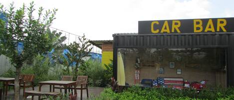 A car-themed bar with outdoor seating and a brick facade.