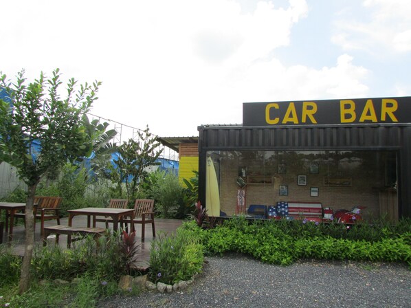 A car-themed bar with outdoor seating and a brick facade.
