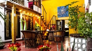 Un interior acogedor con una escalera de madera, un comedor con sillas y una planta en maceta.