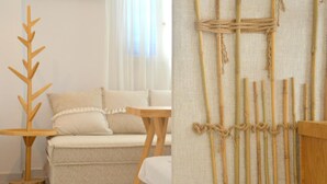 Una habitación con una lámpara de pie de madera con forma de árbol, un sofá y una mesa.