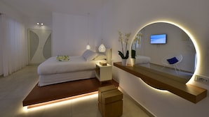 Ein modernes Schlafzimmer mit einem Bett, Nachttischen, einem Spiegel und einem Fernseher.