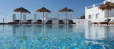 Una piscina al aire libre de temporada, sombrillas