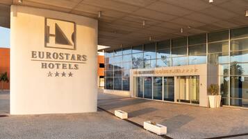 A modern building with a glass facade and a sign reading "Eurostars Hotels".