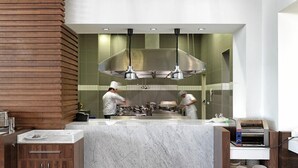 Una cocina moderna con encimera de mármol, paneles de madera y una isla grande.