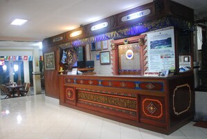 A reception desk with a sign indicating 'ROOM KEY' and 'INFORMATION'.