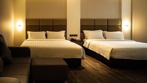 A hotel room with two beds, a sofa, and a nightstand. - KK Times Square Hotel (Kota Kinabalu)