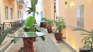 A corridor with potted plants, a glass table, and a door. - Hotel Seri Malaysia Alor Setar (Alor Setar)