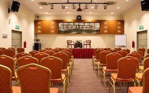 A conference room with rows of chairs, a stage with a red tablecloth, and a whiteboard. - Hotel Seri Malaysia Alor Setar (Alor Setar)