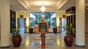 A hotel lobby with a chandelier, potted plants, and a signboard listing room numbers and amenities. - Hotel Seri Malaysia Alor Setar (Alor Setar)