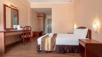 Quarto de hotel com escrivaninha de madeira, cadeira e cama.