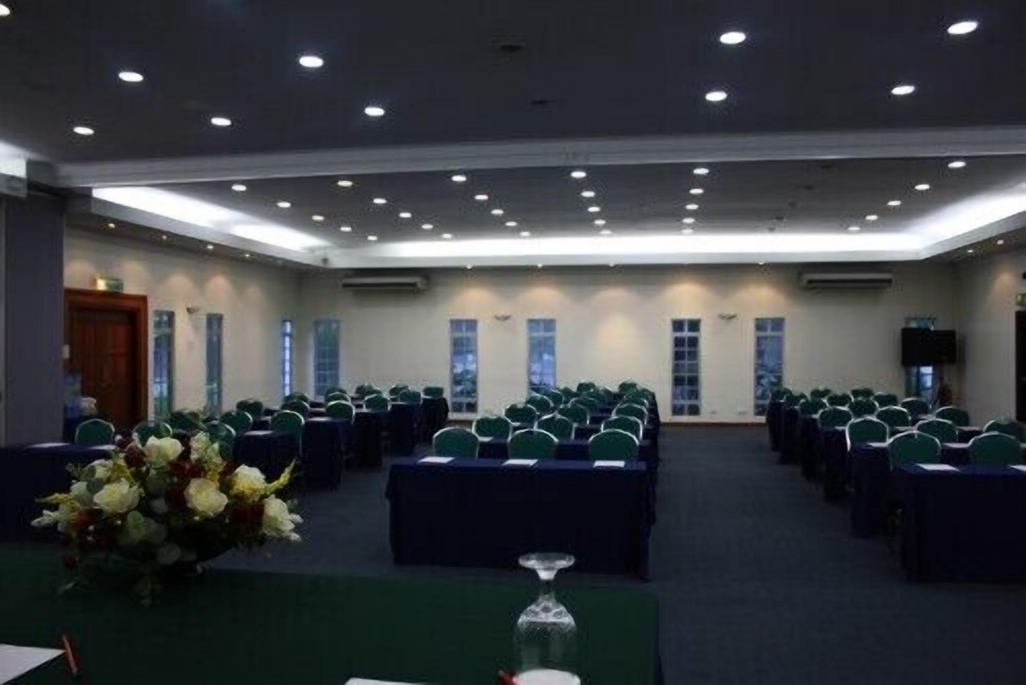 A conference room with rows of chairs, a podium, and a floral arrangement.