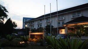 Un hotel con un patio central, varios pisos y un asta de banderas.