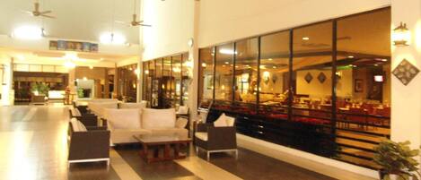 A spacious lobby with a seating area, large windows, and ceiling fans.