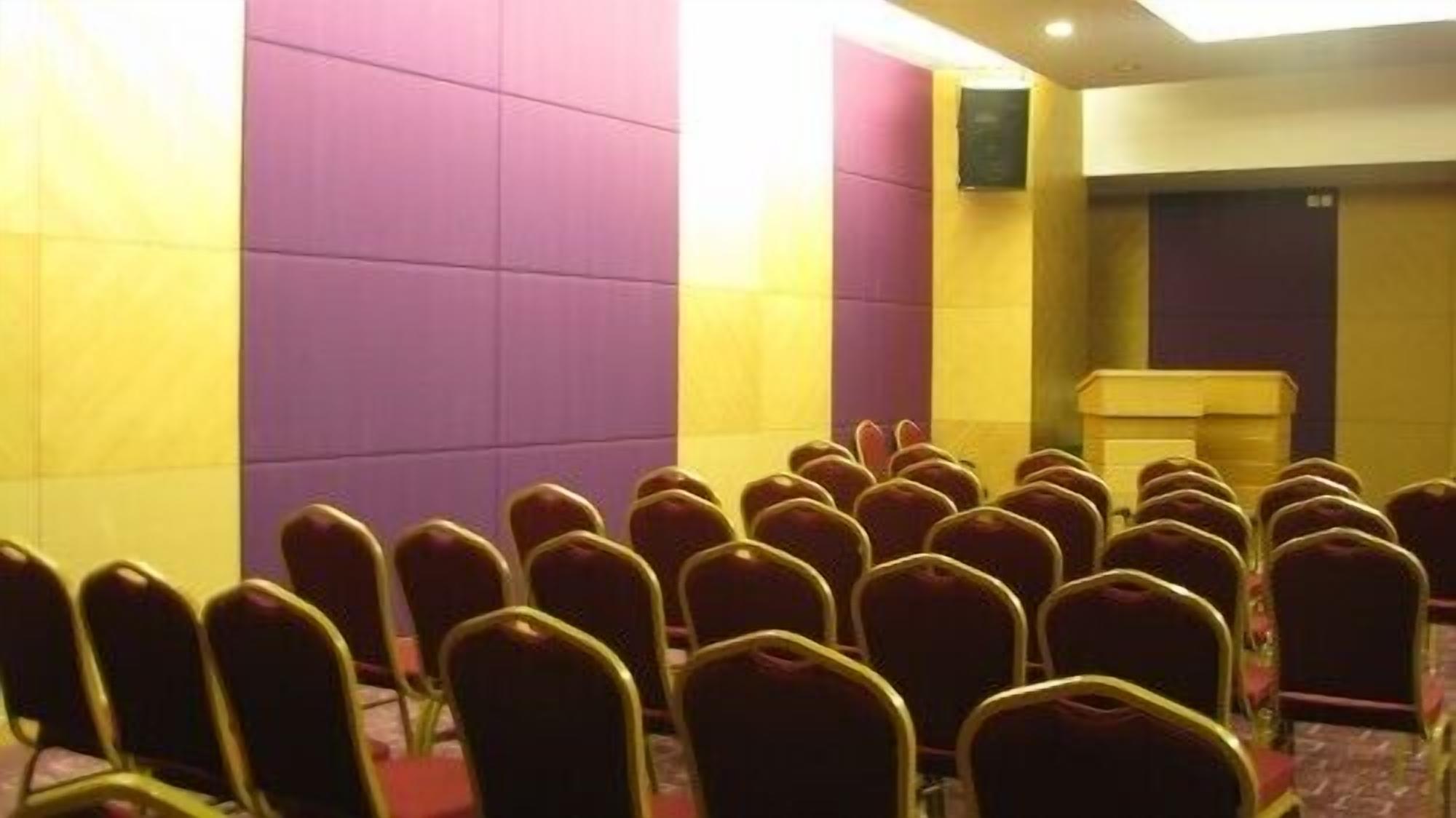 A conference room with rows of chairs and a podium.