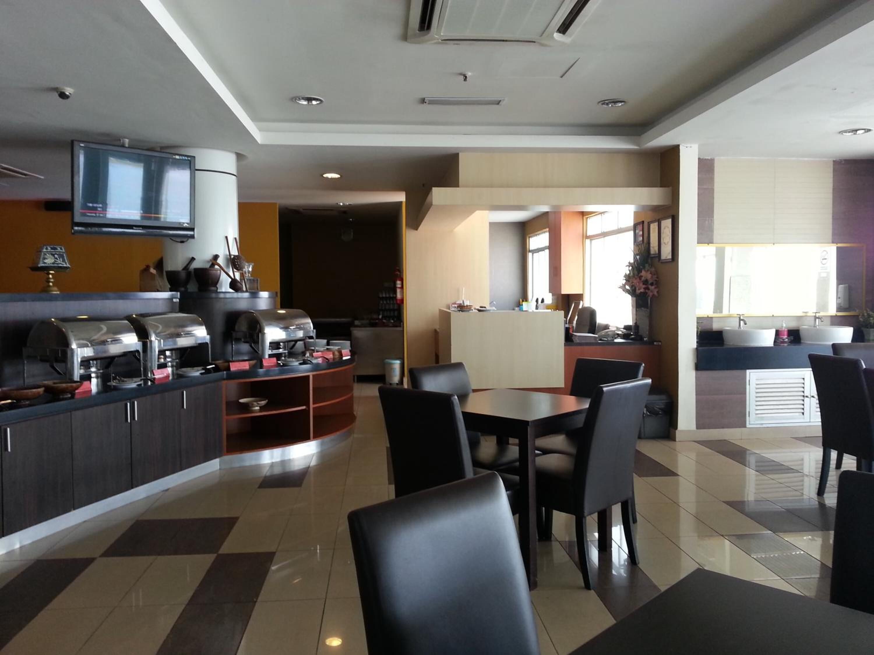 Un vestíbulo de hotel moderno con una estación de café, zona de estar y una recepción.