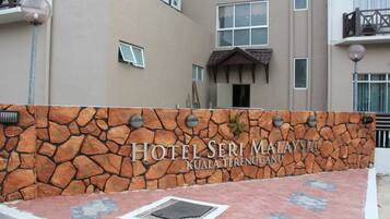 Een stenen muur met het bord 'Hotel Seri Malaysia Kuala Terengganu'.