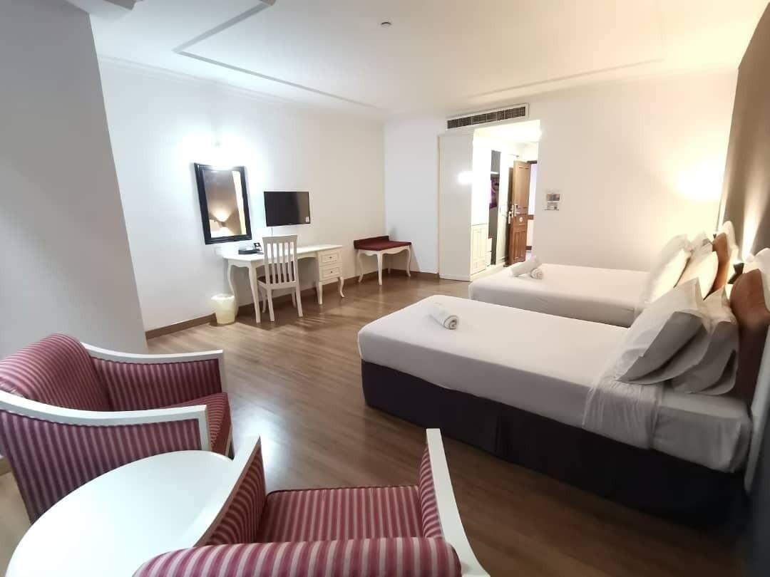 Una habitación de hotel con una cama, un escritorio, una silla y una mesita.