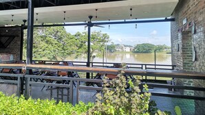 An outdoor seating area with tables and chairs, overlooking a body of water. - Hotel Seri Malaysia Kulim (Kulim)