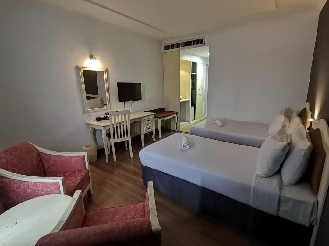 Ein Hotelzimmer mit Bett, Schreibtisch, Stuhl und Fernseher.
