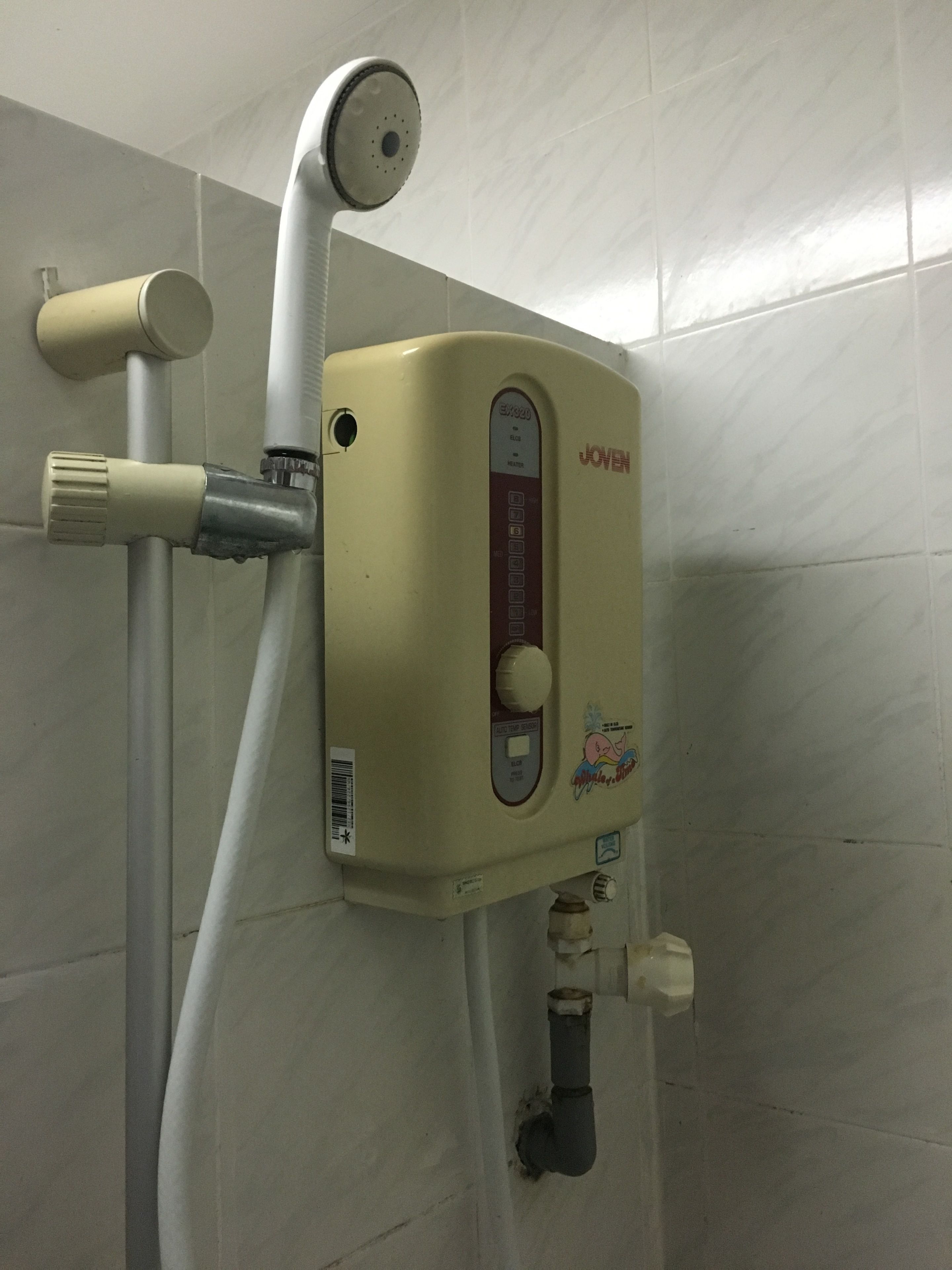 A water heater with a control panel, connected to a showerhead and a faucet.