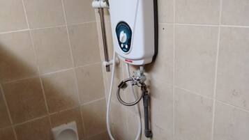 A shower with a handheld showerhead and a wall-mounted control panel.