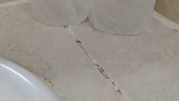 A bathroom with a white sink and two white plastic bags on the countertop.