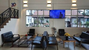 A spacious lobby with a staircase, comfortable seating, a TV, and large windows offering a view of the outside. - Hotel Seri Malaysia Pulau Pinang (George Town)