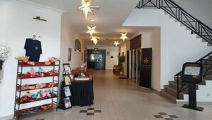 A hotel lobby with a staircase, star-shaped ceiling lights, a shoe display, and a reception desk. - Hotel Seri Malaysia Pulau Pinang (George Town)