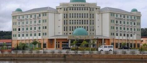 A large, multi-story building with a central dome and smaller domes on the corners.