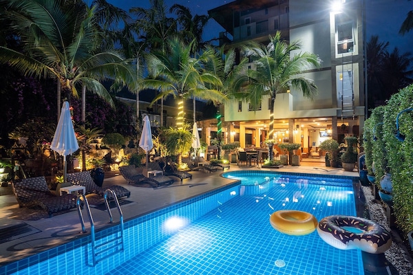Una piscina al aire libre, sillones reclinables de piscina