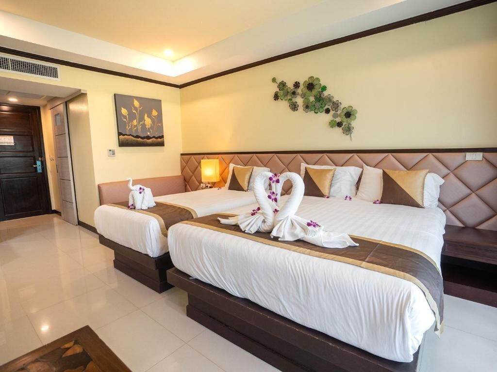 A hotel room with two beds, a large wall-mounted artwork, and a decorative wall piece.
