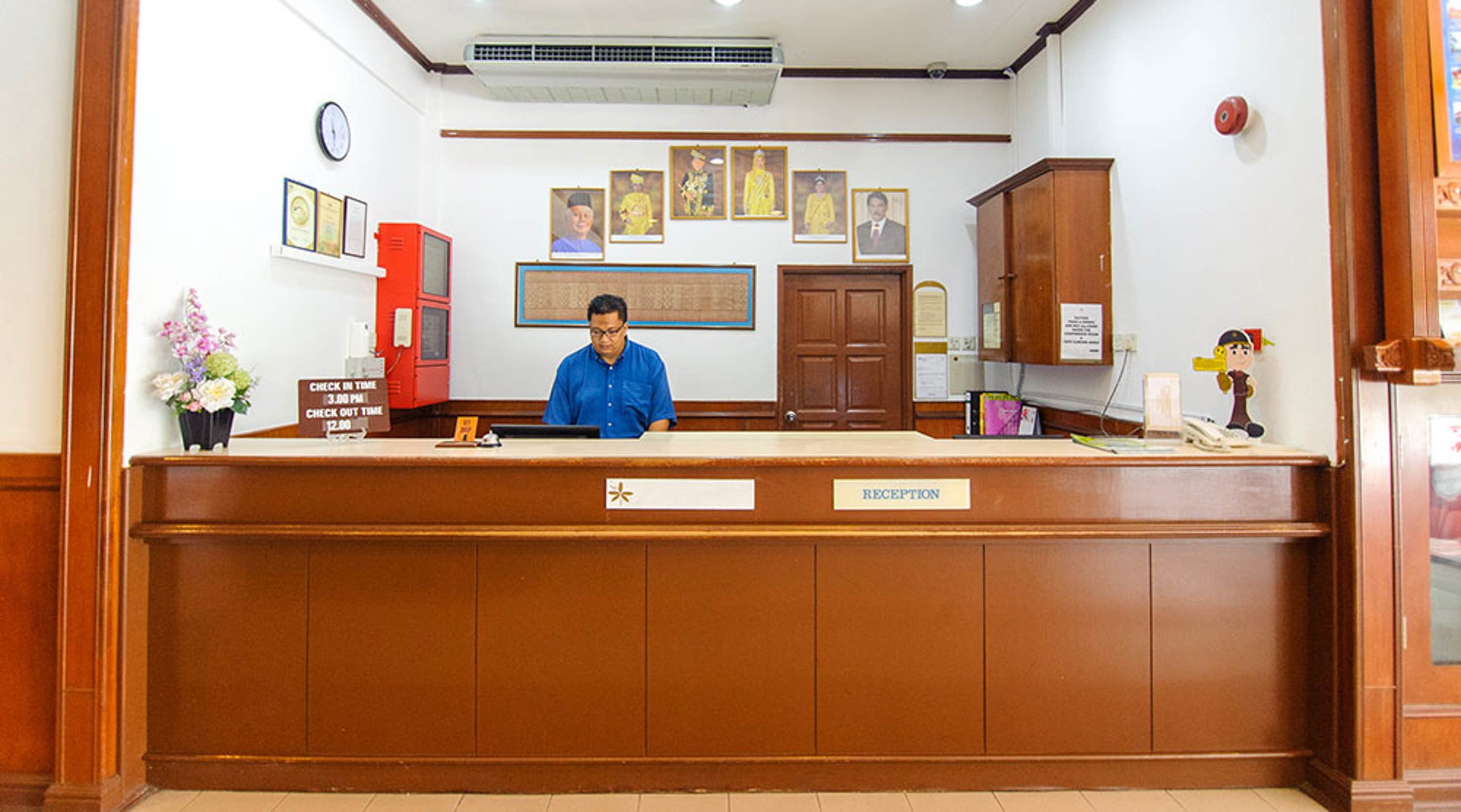 A reception desk with a clock, framed certificates, and a reception sign.