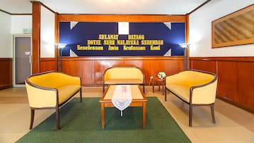A reception area with a reception desk, two armchairs, and a small table with a placemat.
