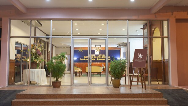 A hotel entrance with glass doors, a reception desk, and potted plants. - Hotel Seri Malaysia Seremban (Seremban)