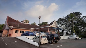 A hotel with a covered parking area, a ramp for accessibility, and a sign indicating a parking fee. - Hotel Seri Malaysia Seremban (Seremban)