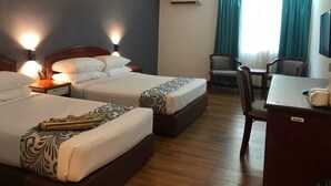 A hotel room with two beds, a desk, a chair, an air conditioning unit, and a window with curtains. - Hotel Seri Malaysia Taiping (Taiping)