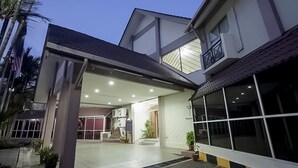 A modern two-story house with a covered patio, large windows, and a well-lit interior. - Hotel Seri Malaysia Temerloh (Temerloh)